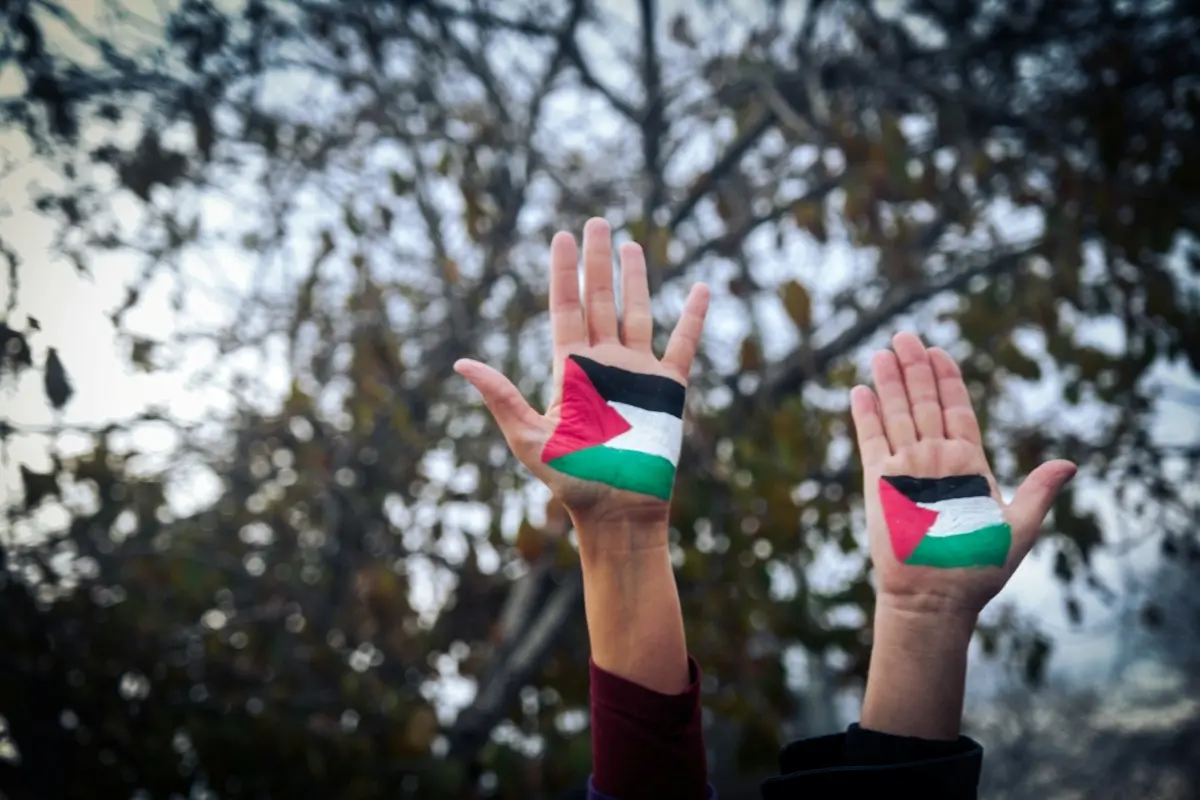 Foto de dos manos con la bandera de Palestina